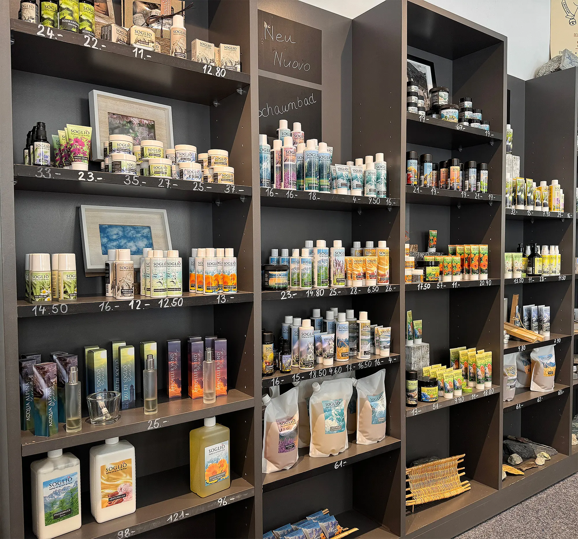 Scaffale di prodotti per la cura e la bellezza, con diverse bottiglie e confezioni di cosmetici esposte. I prodotti sono organizzati su ripiani scuri con etichette numerate.