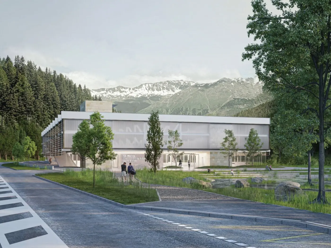 Un edificio moderno e luminoso circondato da alberi e montagne. Il design presenta grandi finestre e facciate in vetro, mentre una strada conduce all'ingresso principale.