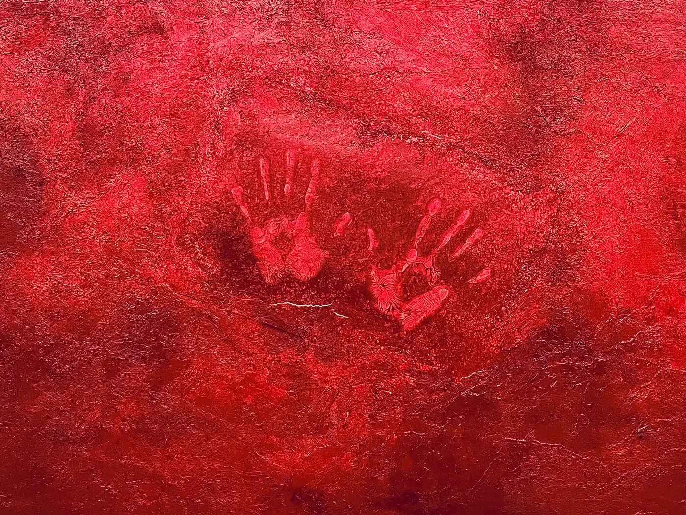 Due mani impressionate su uno sfondo rosso intenso e texture astratta.
