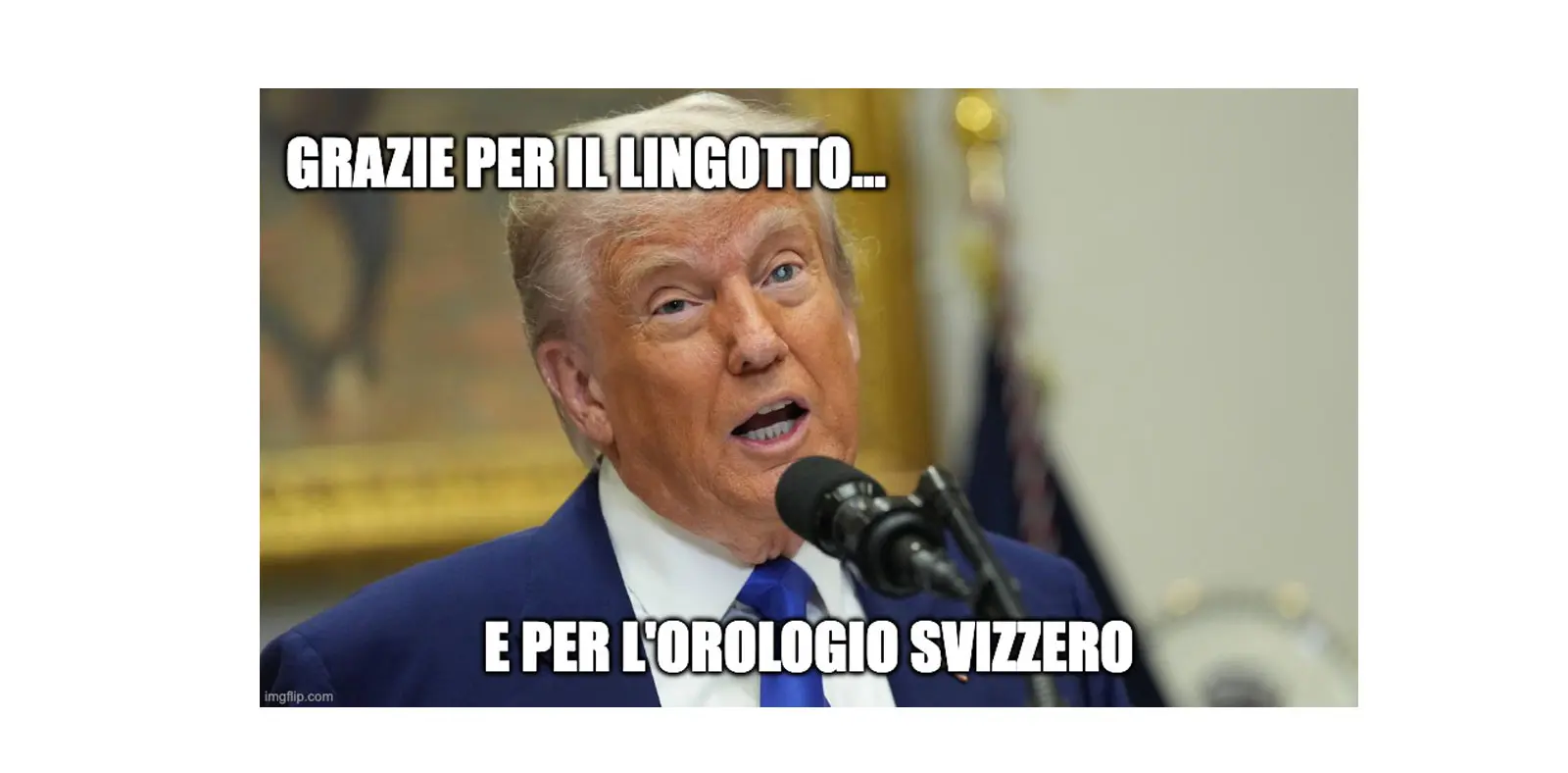 Donald Trump parla al microfono con espressione seria. Sullo sfondo si intravede un ambiente ufficiale. Il testo sopra di lui esprime un ringraziamento per un lingotto e un orologio svizzero.